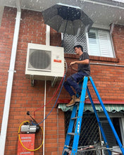 Load image into Gallery viewer, Refrigeration Mechanic Staying Dry While Working On A Split System In Wet Conditions.