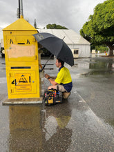 Load image into Gallery viewer, An Electrician Staying Protected From The Rain While Using The Trade Shade - Magnetic Umbrella Holder