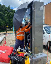 Load image into Gallery viewer, An Electrician Setting Up The Trade Shade - Magnetic Umbrella Holder For Shade Before He Begins Work On A Switchboard.

