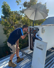 Load image into Gallery viewer, The Trade Shade - Magnetic Umbrella Holder Providing Shade For A HVAC Technician Working On A Ducted Air Conditioner.
