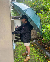 Load image into Gallery viewer, A Australian Meter Installer Electrician Staying Protected From The Rain Using The Trade Shade - Magnetic Umbrella Holder.
